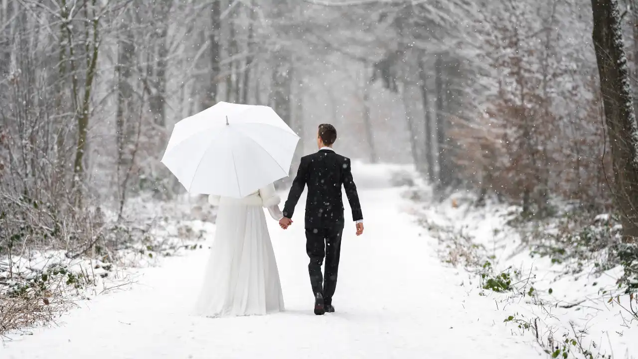 Fotografie ženicha a nevěsty jdoucí zimní krajinou